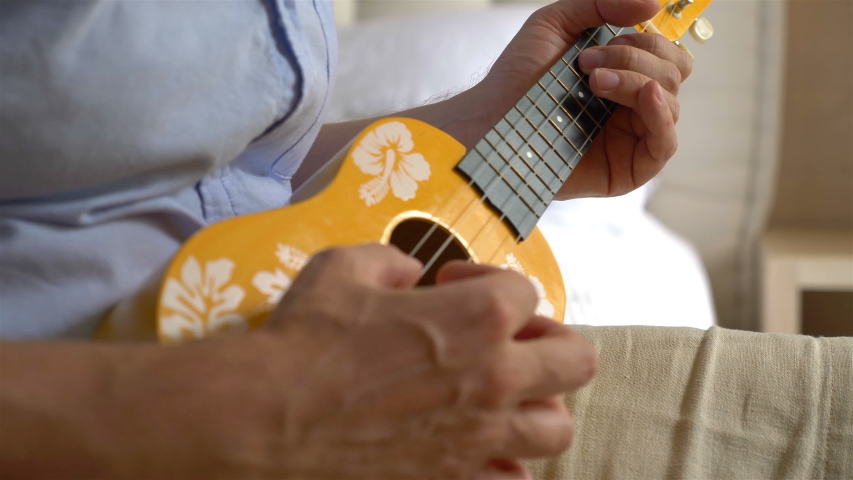 Musician playing ukulele in 4K slow motion 60fps
