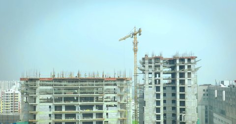 Time lapse of tower crane and construction workers working on under construction building or skyscraper in India
