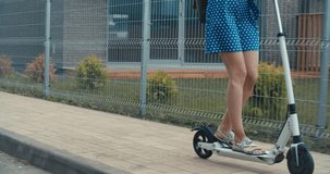 Attractive woman riding on the electric kick scooter. 4K slow motion video footage 60 fps