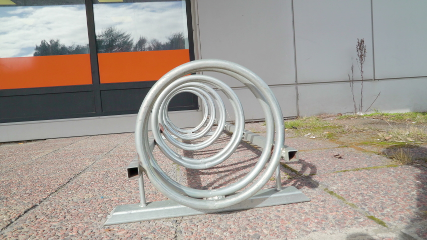 A metal bike carrier outside the house near the glass door