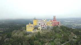 The Pena Palace, a Romanticist castle in the municipality of Sintra, Portugal, Lisbon district, Grande Lisboa, aerial view, shot from drone. Camera in motion