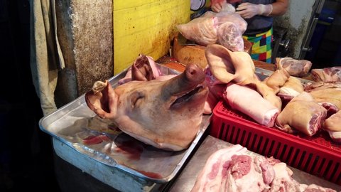 Pig Head Lying on Pork Vendor Table.