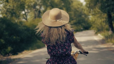 Hair Flowing On Bike Holidays Cycling.Cyclist Woman Happy In Hat Hair Blowing.Girl Wearing Dress On Bike.Cycling Pretty Girl In Hat Vacation Holiday Fun Recreation Sport.Happy Cyclist Leisure Workout