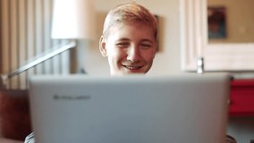 Happy Smiling Teenager Reacting to Something on the Laptop Screen