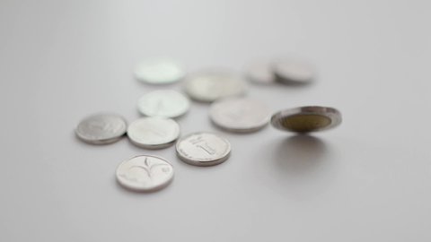 Slow motion spin of a 10 shekel coins next to other Israeli coins