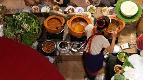 Anonymous woman selling food in Asian food court. Unrecognizable female seller standing near stall and serving traditional Thai food in street food court. Top down view