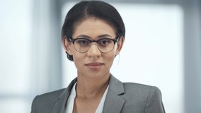 happy african american businesswoman in glasses looking at camera