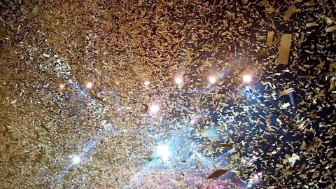Gold confetti floating in the air during a concert