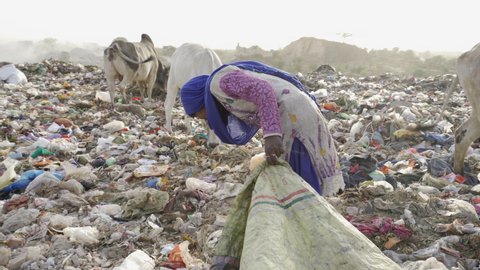 Young people recycling rubbish from landfill site in India. 