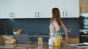 Business woman preparing breakfast in a hurry in luxury kitchen. Busy mother running to work. Multitasking woman making food in a rush in private house.