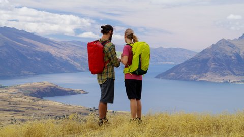 Active Caucasian adventure travelers reading map on the hike of Mt Aspiring Lake Wakatipu New Zealand RED WEAPON