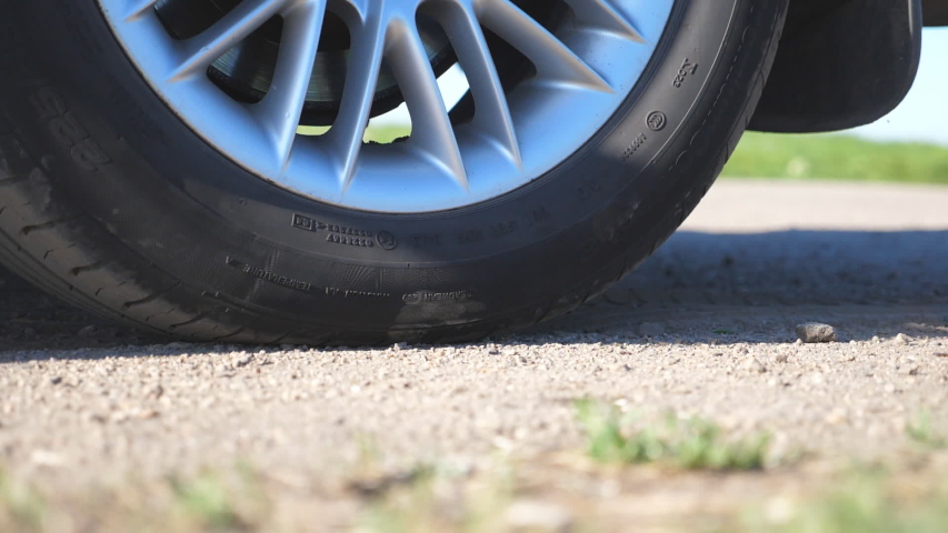 Wheel of car are slip on a dirt road during start of movement. Small stones and dirt is fly out from under the tire of a auto. Vehicle quickly beginning motion.Concept of burnout. Slow motion Close up Royalty-Free Stock Footage #1031135564