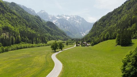 Logar valley Slovenia aerial view. Drone 4K summer footage from Logarska dolina under the Slovenian Alp mountains with a leading road to a traditional tourist farm.