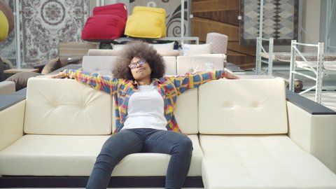 african american woman with an afro hairstyle chooses the furniture superstore