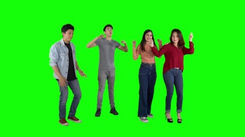 Group of happy young people dancing together in the studio. Shot in 4k resolution with green screen background