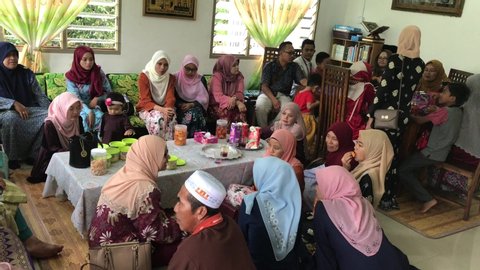 Batu Pahat, Malaysia -June 6th, 2019 : The family ate the food while visiting their relatives during Eid al-Fitr celebration .Family, Happiness and Forgiveness Concept.