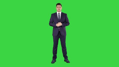 Handsome businessman looking in camera and talking on a Green Screen, Chroma Key.
