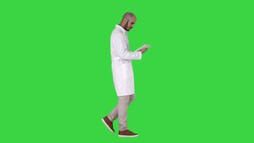 Doctor checking his tablet walking on a Green Screen, Chroma Key. - Powered by Shutterstock - Get 15% off with code: PIKWIZARD15