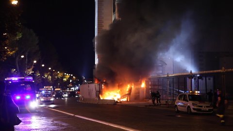 Paris, France - April 6, 2019: Fire in Paris with cars and firemens near Museum. Firefighter, Dark Smoke, burning fire, monument. Fireman running and policeman in police car passing by with speed.