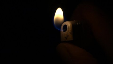 
In this slow-motion shot you can see how the darkness is illuminated by a lighter. In the light of the flame you can see a hand, which operates the gas lighter.