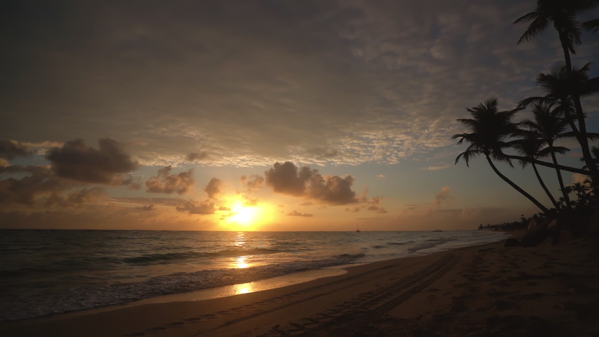 Sunrise over tropical beach in Punta Cana, Dominican Republic. Running woman.