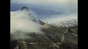 Aerial view of Cape Town city skyline, harbour and cliff from Table Mountain NP nature reserve, top of the mountain with cityscape. Historical archival footage in Cape Town city of 1980s South Africa