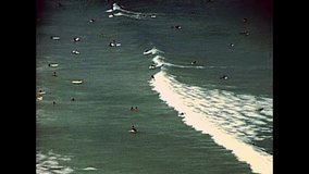 Aerial view of Noordhoek Beach. Surfing in Cape Town. Surfers riding big waves of Atlantic coast in Table Mountain National Park. Archival of Cape Town city of South Africa in 1980s