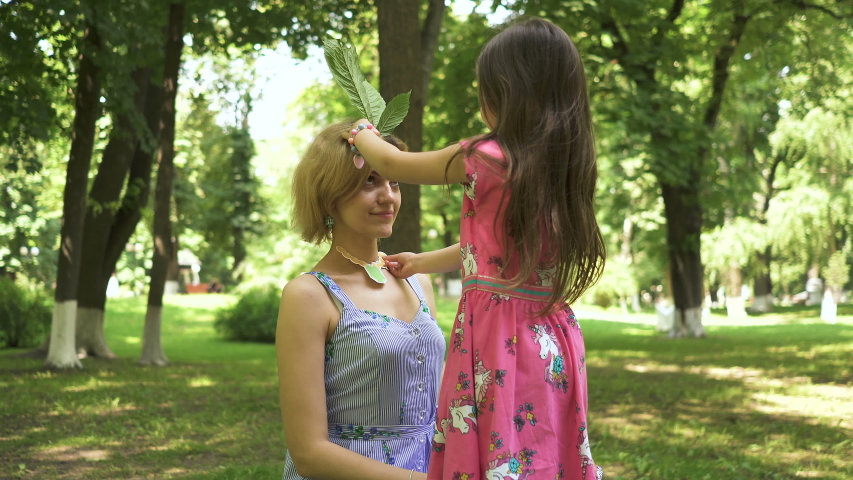 4K. Happy mother and daughter child, playing  in city park.