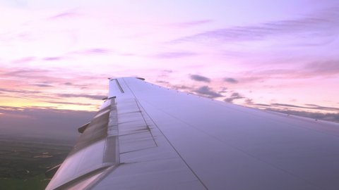 Airplane Wing in Flight - Looking Out From the window with twilight sky background.