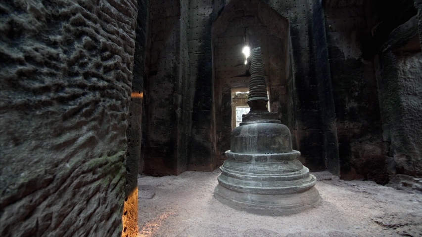 Sliding view of caucasian woman with backpack exploring and touching Preah Khan and central stupa. It