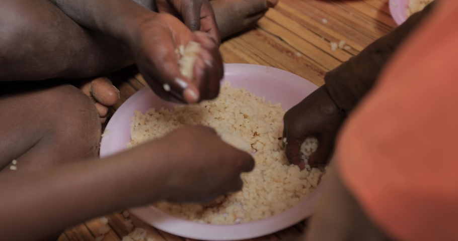 A group of kids eating rice with their hands in a mosque in Uganda | Shutterstock HD Video #1031212037