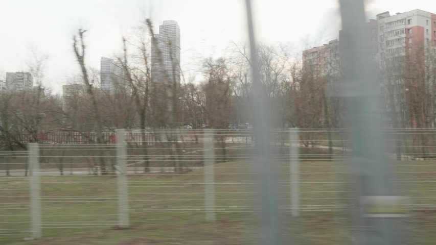 View of Prospect Mira avenue with cars and buildings from window of moving train