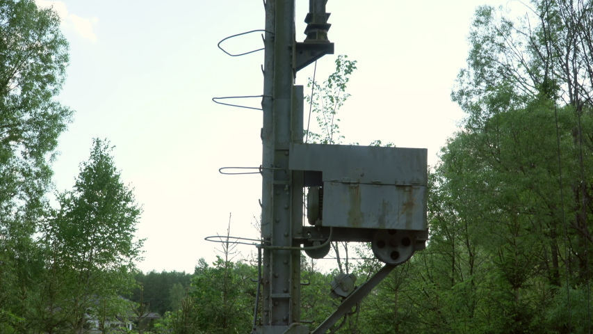 Old Pole holding voltage electric power lines in the middle of the wood. Abandoned pole with electricity which are a prerequisite for driving train.