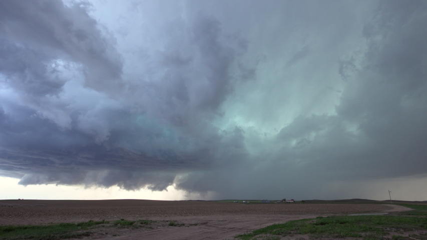 Clouds spinning in the sky during severe storm in Nebraska as lightning flashes over the plains.