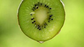 Close up fresh kiwi slice with water drops in green background,freshness concept