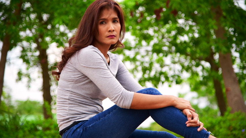 4K video of Asian woman smiling in grey shirt, Thailand.