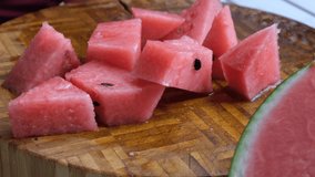 Bite size watermelon on wooden board. Selective focus.
