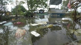 Plastic and styrofoam bottles, bags and food containers dumped in river and flow into sea