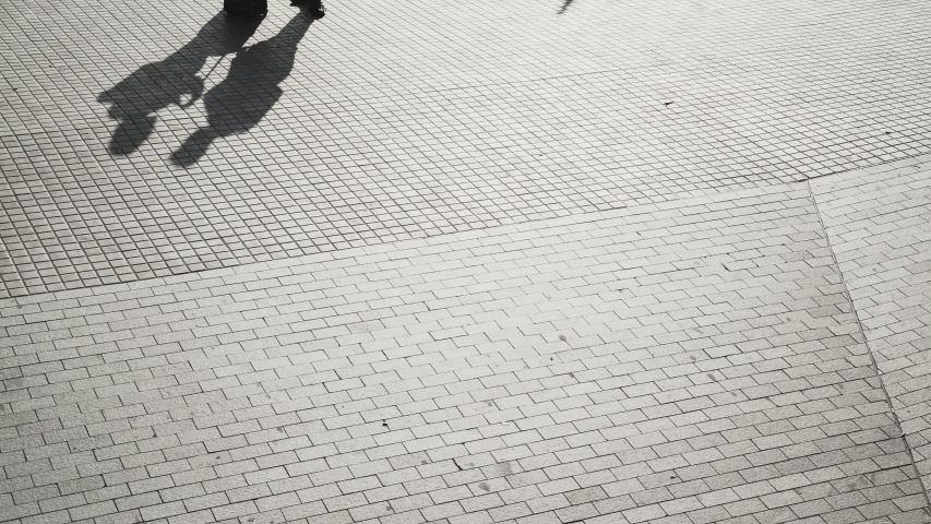 Black and white shadows moving from the metro. People walking silhouette in the morning light. Early hours in the city. Urban movements and creative background. Bricks on the street of Barcelona