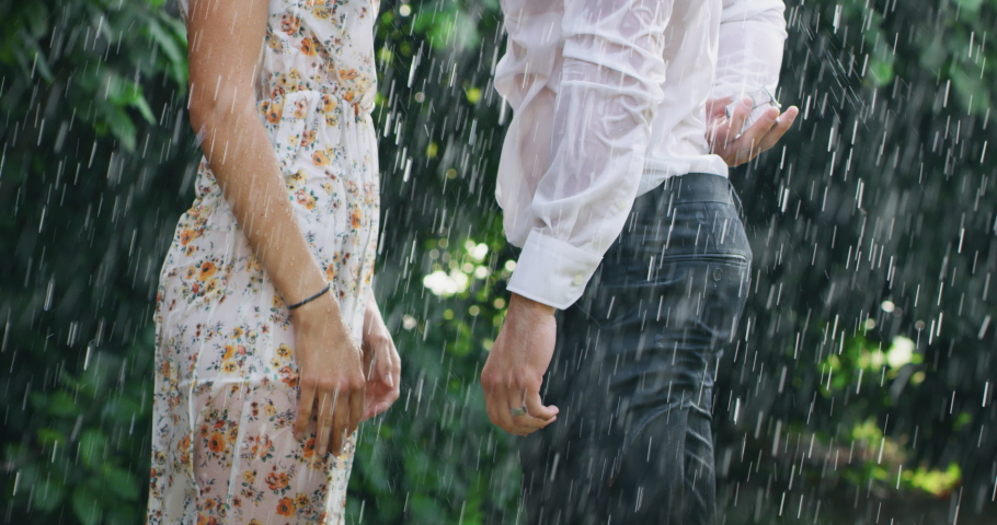 Slow motion of young handsome man is making a proposal of marriage to his fiancee under the rain on a background of green trees. Royalty-Free Stock Footage #1031236742