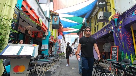 
Singapore, Singapore-June 1, 2019: People in Haji Lane. It is a famous place for tourists. There are unique murals, cafes, pubs and bars, including shopping stores. 
