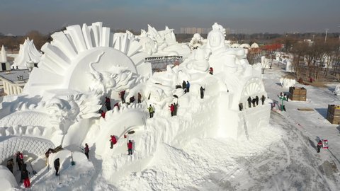 HARBIN, CHINA – JANUARY 2019: Rotating drone shot of people shoveling snow making beautiful artistic sculpture, in preparation of the Harbin ice festival in China
