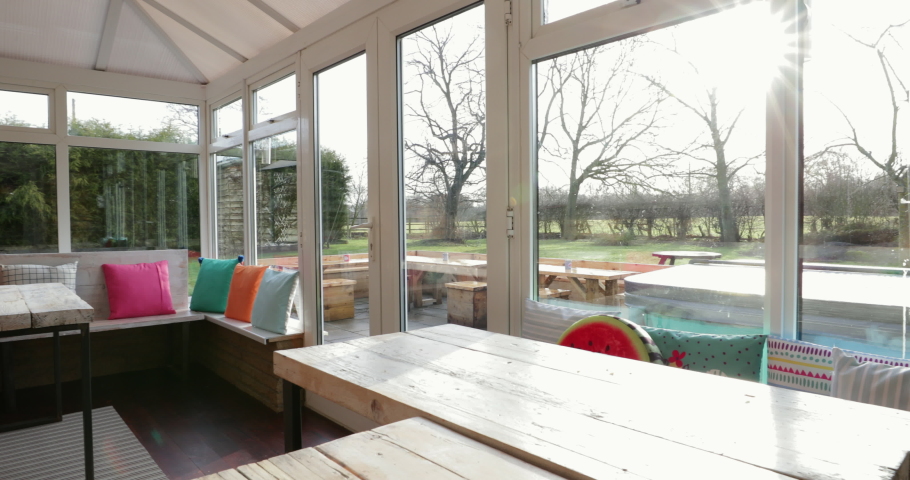 Panning shot of an empty room shot of a cosy looking conservatory. Royalty-Free Stock Footage #1031250647