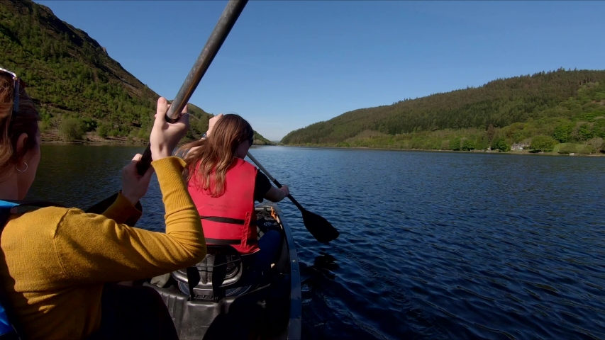 Cinematic Canoe Adventure Trip On Calming Lake With Two Young Women.