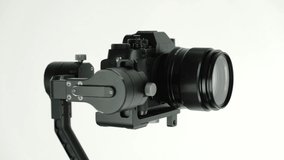 New innovative three-axis stabilizer with digital camera rotates on white background. 4k. Presentation.