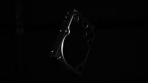 Hard disk drive spinning in space isolated on black background