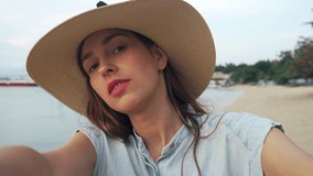 Attractive Young Woman Having Video Chat Using Smartphone and Saying Hello on Tropical Beach. Girl in Hat Taking, Blogging Vlogging, Video Call Enjoying, Showing Tropical Nature Background View 4K