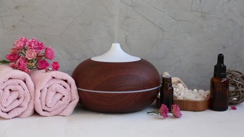 Spa aromatherapy diffuser with towels, essential oils bottles, bath salt. Spa still life setting