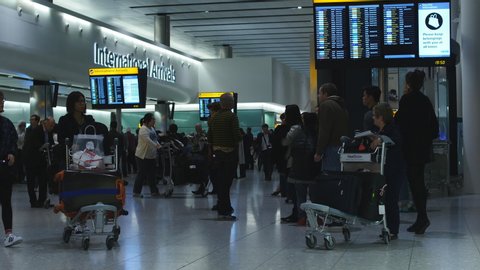 
HEATHROW, UNITED KINGDOM. JULY 13 2015. Busy Heathrow airport operating in the summer. International passengers arriving in the United Kingdom.