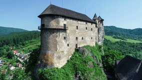 Orava castle - Oravsky Hrad in Oravsky Podzamok village in Slovakia. Medieval stronghold on extremely high and steep cliff by the Orava River. Aerial revealing video in summer